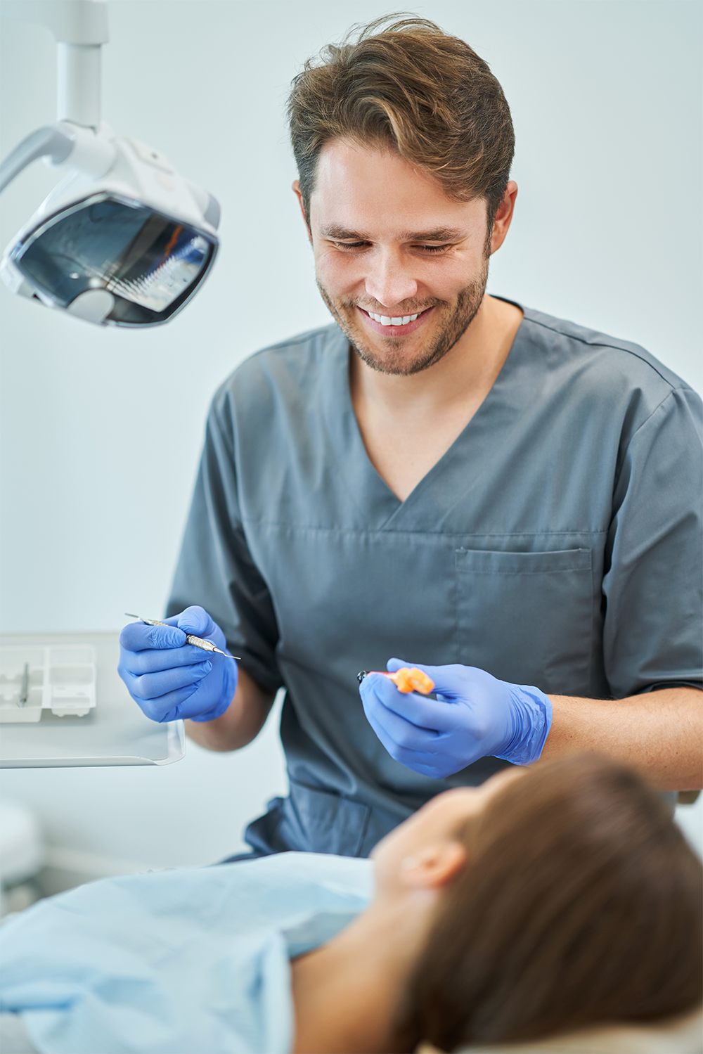 Dentist talking to patient on Dental chair - Oak Mountain Denture and Implant Center