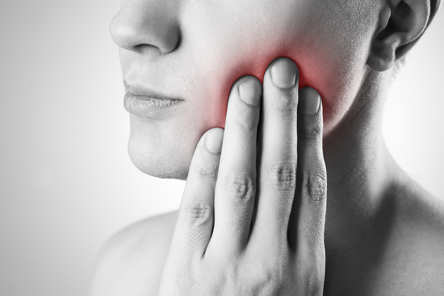 Woman touching jaw due to toothache and gum pain - Oak Mountain Denture and Implant Center.