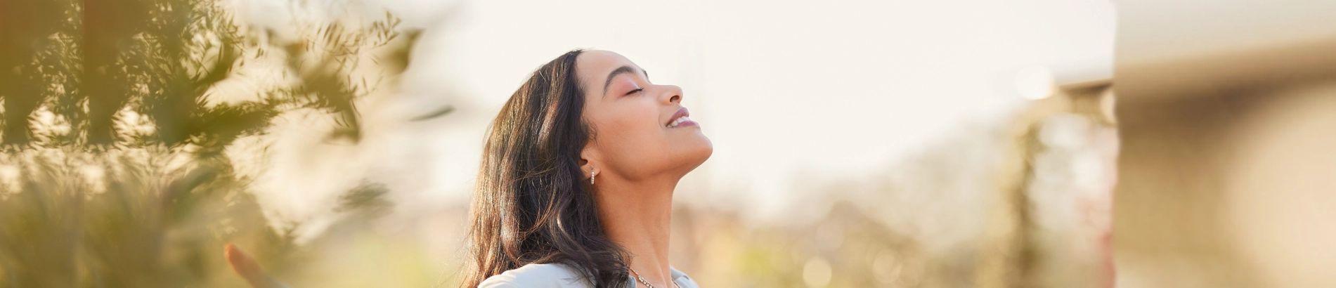 Image 1: Smiling woman showing her healthy teeth outdoors after a successful dental treatment.